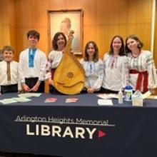 Band members with instrument standing in front of a table