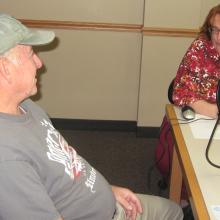 Man sitting and talking to a woman