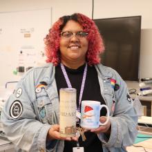 Person holding a tumbler and a mug