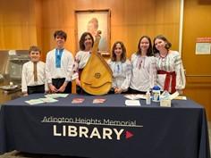 Band members with instrument standing in front of a table