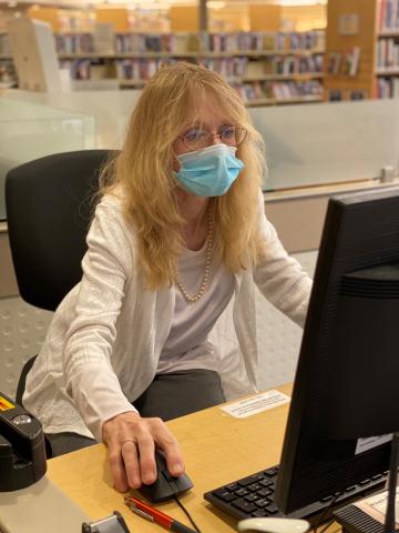 Account Services staff member Audrey checks out last Wednesday’s Fox Tracks for an update on what’s going at the libraries this week.