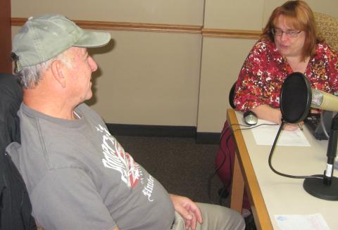 Man sitting and talking to a woman