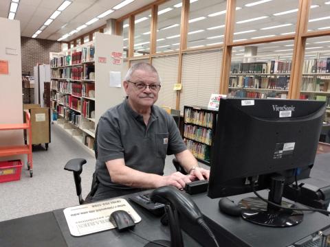 photo of man at a desk with computer