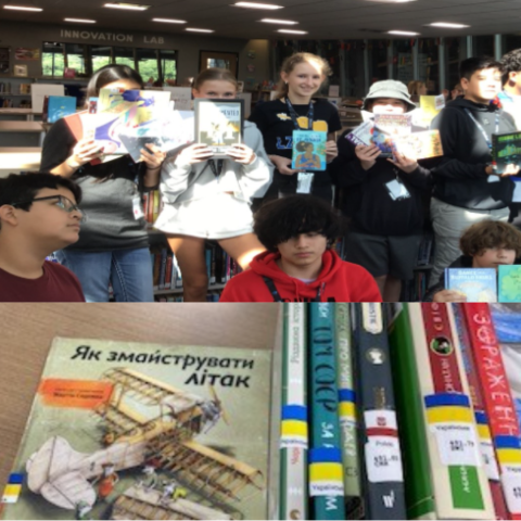 A group of students holding various books, various books in various languages. 